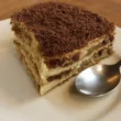 Tiramisù casalingo servito in bicchiere con crema al mascarpone, savoiardi e cacao amaro