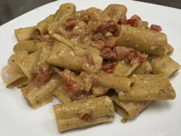Rigatoni con pesto di rucola, pomodorini datterini, noci e gamberetti