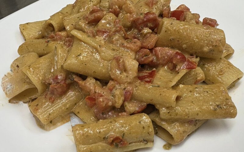 Rigatoni con pesto di rucola, pomodorini datterini, noci e gamberetti
